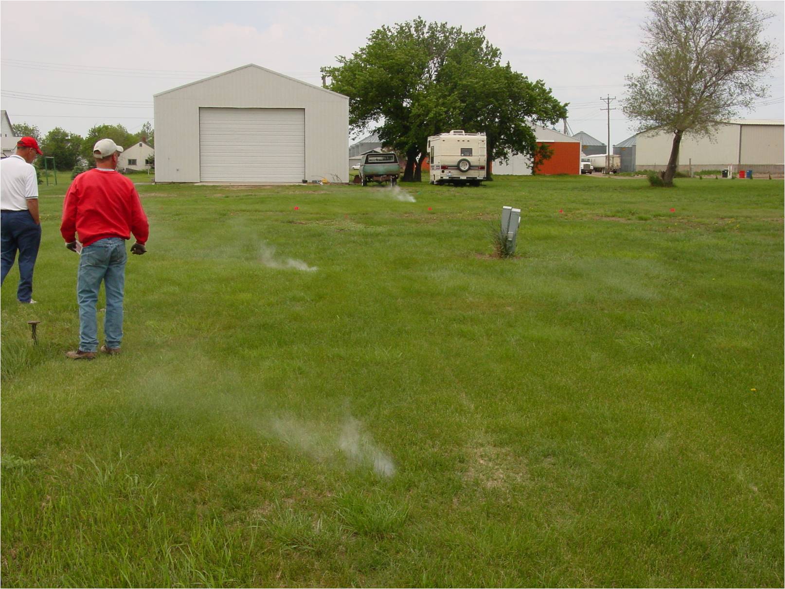 Smoke testing a sewer line with smoke rising out of the ground